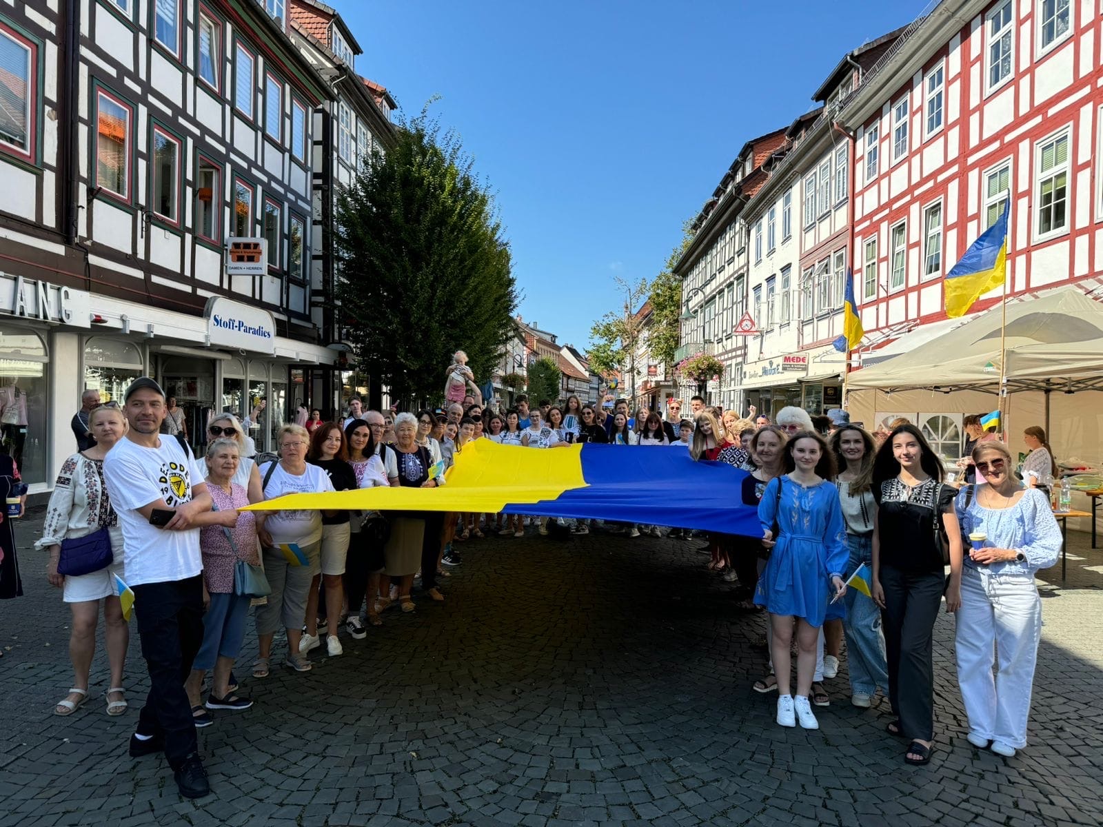  Eine große Ukraine-Flagge wird von einer Menschenmenge am Unabhängigkeitstag der Ukraine durch die Breite Straße in Northeim getragen.